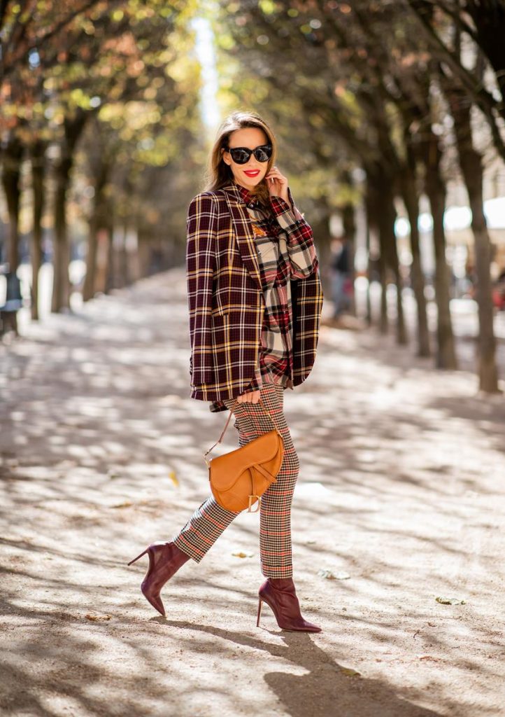 Alexandra Lapp in a Plaid Allover Look is wearing a burgundy and yellow checked wool blazer from Burberry, embroidered checked oversized shirt in red, black, white by Gucci, multi-coloured high-waisted checked trousers from P.A.R.O.S.H., browny embossed leather belt by Max Mara, a vintage Dior saddle bag in cognac, purple Gianvito Rosso boots and black Audrey sunglasses by Celine during Paris Fashion Week Womenswear Spring/Summer 2019 on September 25, 2018 in Paris, France.