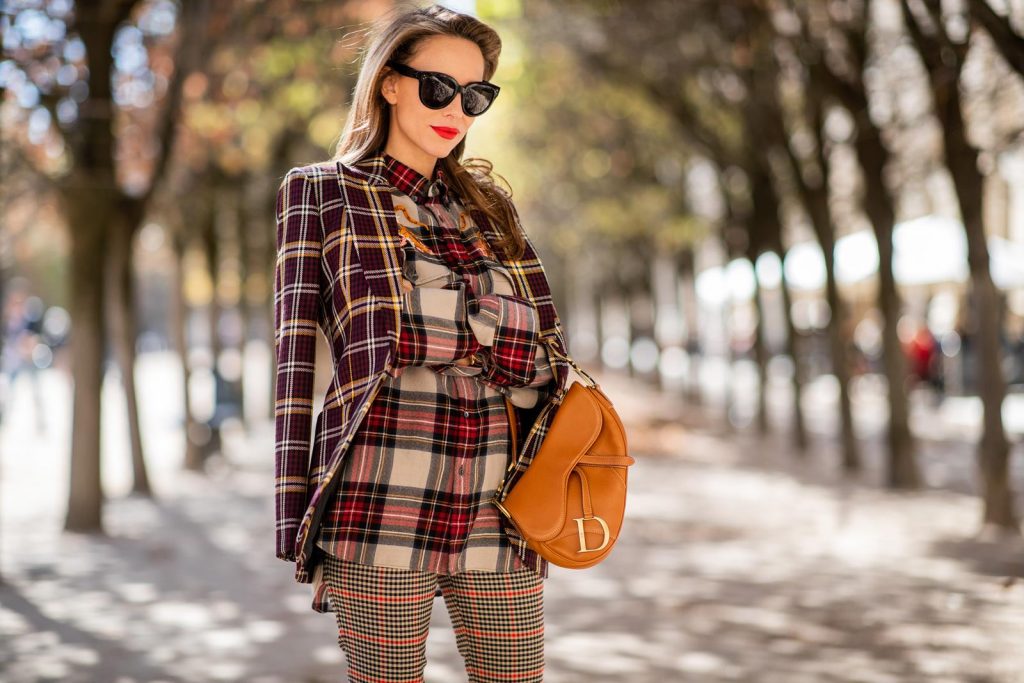 Alexandra Lapp in a Plaid Allover Look is wearing a burgundy and yellow checked wool blazer from Burberry, embroidered checked oversized shirt in red, black, white by Gucci, multi-coloured high-waisted checked trousers from P.A.R.O.S.H., browny embossed leather belt by Max Mara, a vintage Dior saddle bag in cognac, purple Gianvito Rosso boots and black Audrey sunglasses by Celine during Paris Fashion Week Womenswear Spring/Summer 2019 on September 25, 2018 in Paris, France.