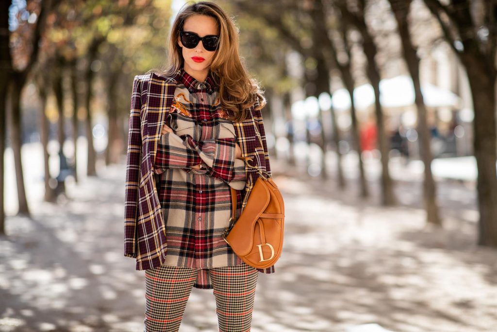 Alexandra Lapp in a Plaid Allover Look is wearing a burgundy and yellow checked wool blazer from Burberry, embroidered checked oversized shirt in red, black, white by Gucci, multi-coloured high-waisted checked trousers from P.A.R.O.S.H., browny embossed leather belt by Max Mara, a vintage Dior saddle bag in cognac, purple Gianvito Rosso boots and black Audrey sunglasses by Celine during Paris Fashion Week Womenswear Spring/Summer 2019 on September 25, 2018 in Paris, France.