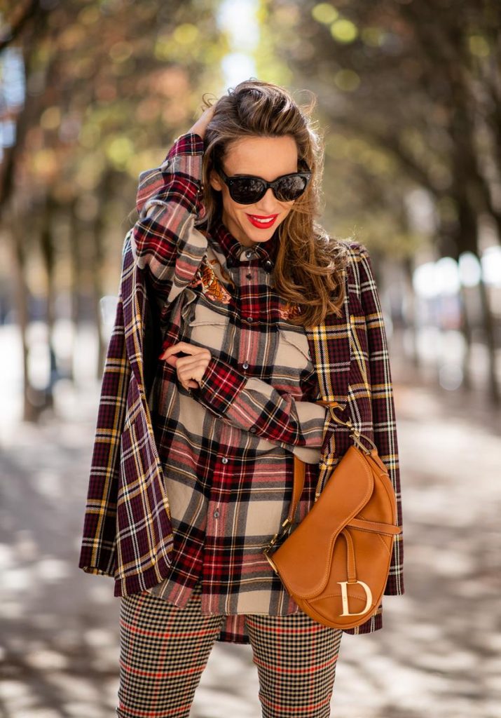 Alexandra Lapp in a Plaid Allover Look is wearing a burgundy and yellow checked wool blazer from Burberry, embroidered checked oversized shirt in red, black, white by Gucci, multi-coloured high-waisted checked trousers from P.A.R.O.S.H., browny embossed leather belt by Max Mara, a vintage Dior saddle bag in cognac, purple Gianvito Rosso boots and black Audrey sunglasses by Celine during Paris Fashion Week Womenswear Spring/Summer 2019 on September 25, 2018 in Paris, France.