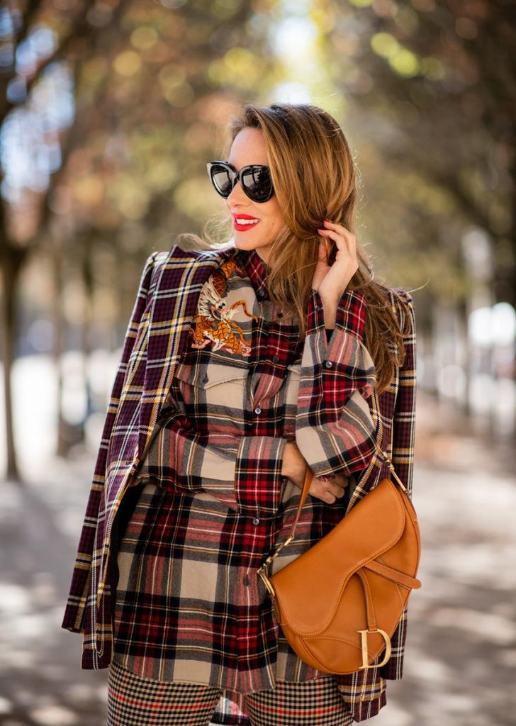 Alexandra Lapp in a Plaid Allover Look is wearing a burgundy and yellow checked wool blazer from Burberry, embroidered checked oversized shirt in red, black, white by Gucci, multi-coloured high-waisted checked trousers from P.A.R.O.S.H., browny embossed leather belt by Max Mara, a vintage Dior saddle bag in cognac, purple Gianvito Rosso boots and black Audrey sunglasses by Celine during Paris Fashion Week Womenswear Spring/Summer 2019 on September 25, 2018 in Paris, France.