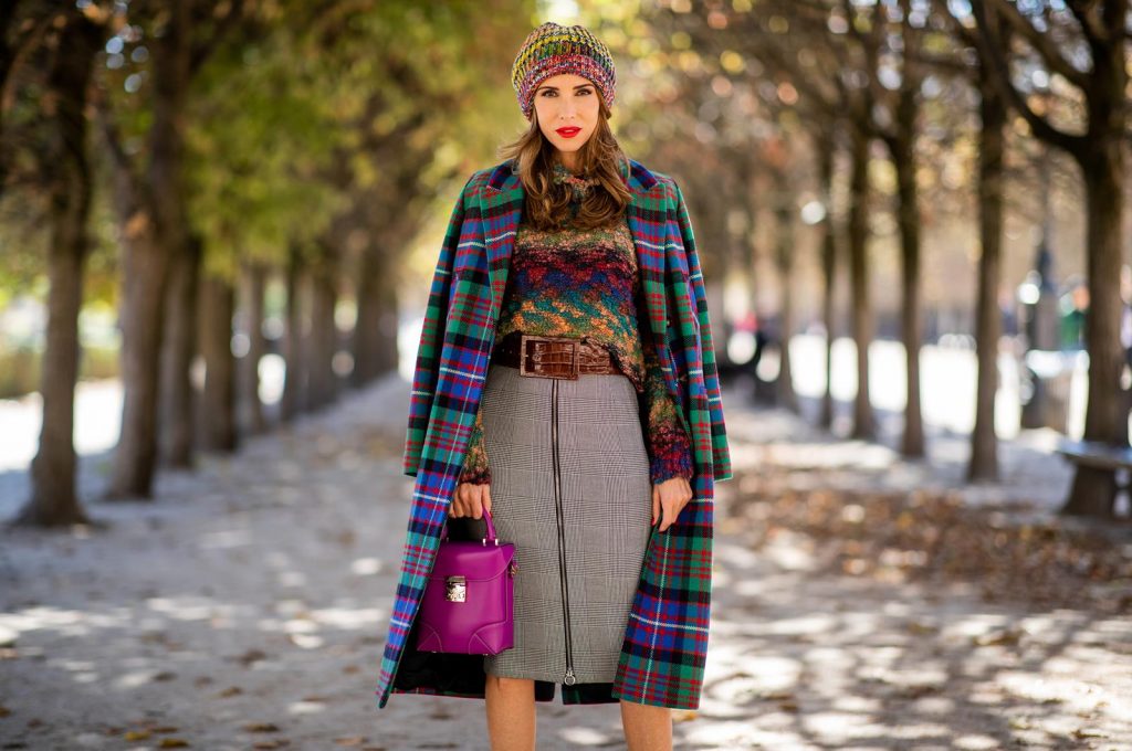 Alexandra Lapp in a Mixed Prints Look wearing a long multicolored plaid coat and a wool turtleneck multicolored sweater from Ouì, a black and white plaid slim cut skirt with a zipper up front from Ouì, a brown waist belt from Max Mara, black suede high heels from Christian Louboutin, the Soft Berlin Crossbody Bag in Viva Lilac from MCM, a multicolored wool hat from Missoni, purple black striped socks by H&M and the black Audrey sunglasses from Celine during Paris Fashion Week Womenswear Spring/Summer 2019 on September 25, 2018 in Paris, France.