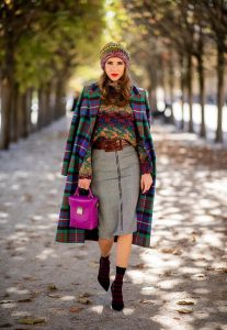 Alexandra Lapp in a Mixed Prints Look wearing a long multicolored plaid coat and a wool turtleneck multicolored sweater from Ouì, a black and white plaid slim cut skirt with a zipper up front from Ouì, a brown waist belt from Max Mara, black suede high heels from Christian Louboutin, the Soft Berlin Crossbody Bag in Viva Lilac from MCM, a multicolored wool hat from Missoni, purple black striped socks by H&M and the black Audrey sunglasses from Celine during Paris Fashion Week Womenswear Spring/Summer 2019 on September 25, 2018 in Paris, France.