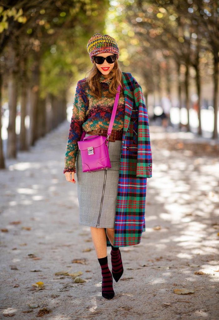 Alexandra Lapp in a Mixed Prints Look wearing a long multicolored plaid coat and a wool turtleneck multicolored sweater from Ouì, a black and white plaid slim cut skirt with a zipper up front from Ouì, a brown waist belt from Max Mara, black suede high heels from Christian Louboutin, the Soft Berlin Crossbody Bag in Viva Lilac from MCM, a multicolored wool hat from Missoni, purple black striped socks by H&M and the black Audrey sunglasses from Celine during Paris Fashion Week Womenswear Spring/Summer 2019 on September 25, 2018 in Paris, France.