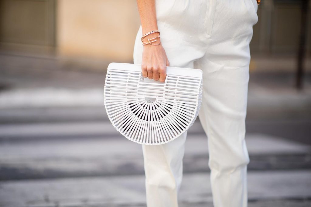Alexandra Lapp in a White Vibes Look wearing white cropped trousers by Mansur Gavriel, a short knitted white pullover with a ring detail on the back from Ouì, white high heel boots from Zara, a white Baker Boy vintage hat from Chanel, a white Gaia's Ark bag by Cult Gaia and white Saint Laurent New Wave 213 Lily sunglasses during Paris Fashion Week Womenswear Spring/Summer 2019 on September 25, 2018 in Paris, France.