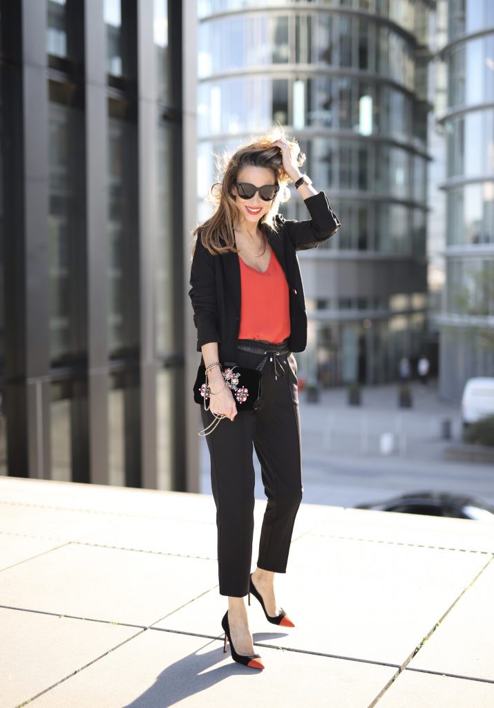 Alexandra Lapp in a Pop of Red Look wearing a stunning black blazer and pants combo from Airfield, mixed with a bright red silk top by Jadicted, an embroidered bag by Roger Vivier and a pair of Manolo Blahnik spiked heels.