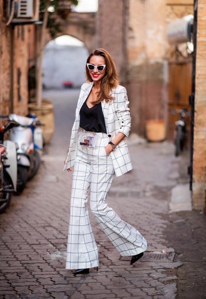 Alexandra Lapp in a ladysuit look, wearing the Pierre double-breasted checkered suit combination in black and white from Rebecca Vallance with matching high rise pants with a flared hem, a black top from Jadicted, black lacquer high heels with sparkling heels from Philipp Plein, a golden Portugieser Chronograph from IWC and a transparent waisted belt bag and white Saint Laurent New Wave 213 Lily sunglasses on November 25, 2018 in Marrakech, Morocco. (Photo by Christian Vierig/Getty Images)