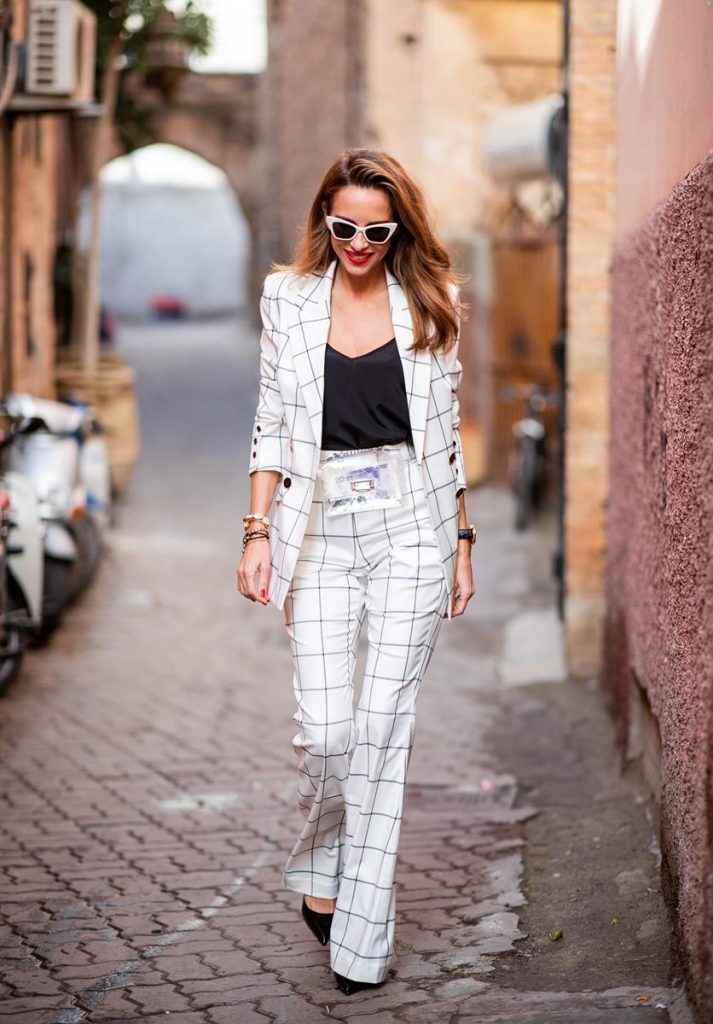 Alexandra Lapp in a ladysuit look, wearing the Pierre double-breasted checkered suit combination in black and white from Rebecca Vallance with matching high rise pants with a flared hem, a black top from Jadicted, black lacquer high heels with sparkling heels from Philipp Plein, a golden Portugieser Chronograph from IWC and a transparent waisted belt bag and white Saint Laurent New Wave 213 Lily sunglasses on November 25, 2018 in Marrakech, Morocco. (Photo by Christian Vierig/Getty Images)