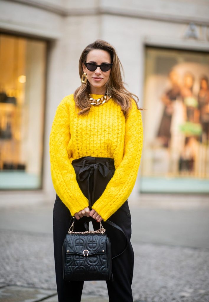 Alexandra Lapp in a Diadora Backpack look, wearing a cropped yellow cable knit sweater from R13 with paperbag pants from H&M, Gianvito Rossi patent leather pumps, Zara earrings and a H&M statement necklace and Aigner Diadora M backpack in during the Berlin Fashion Week Autumn/Winter 2019 on January 17, 2019 in Berlin, Germany. (Photo by Christian Vierig/Getty Images)