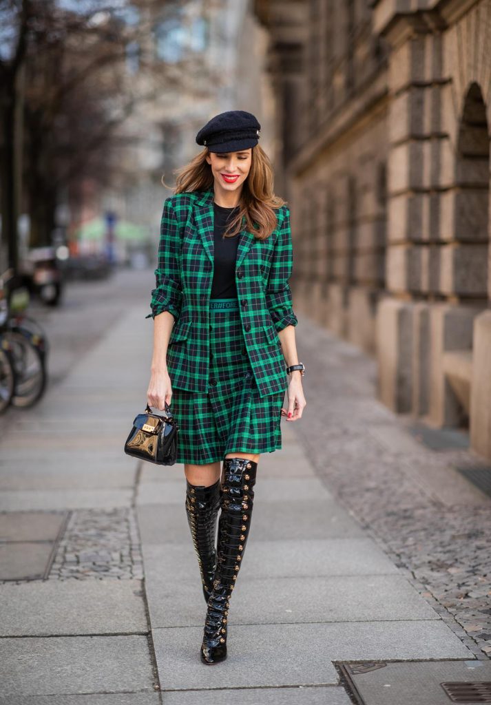 Alexandra Lapp in a checkered suit look, wearing a feminine green checkered Riani blazer with a matching pleated skirt, styled with a Vince knitted T-shirt, a black Chanel tweed baker boy cap, patent leather Louise over-the-knee boots from Christian Louboutin, and a ZAC Zac Posen patent Mini 'Eartha Iconic‘ bag during the Berlin Fashion Week Autumn/Winter 2019 on January 18, 2019 in Berlin, Germany. (Photo by Christian Vierig/Getty Images)