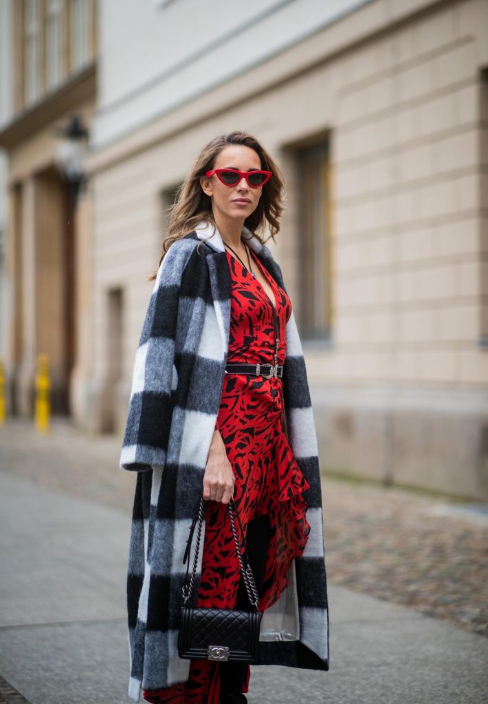 Alexandra Lapp in a Red Animal Print Look, wearing the long Adriana animal print dress from Rixo, a black and white wool coat from Ganni, the Isabel Marant Lamsy cowboy boots, a black boy bag from Chanel, a silver buckled H&M cowboy belt, a western cowboy necklace and red cat-eyed sunglasses by Celine during the Berlin Fashion Week Autumn/Winter 2019 on January 15, 2019 in Berlin, Germany. (Photo by Christian Vierig/Getty Images)