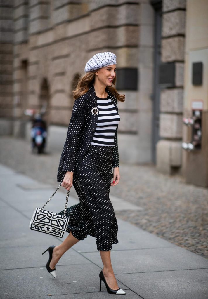 Alexandra Lapp in a tweed beret dot suit look, wearing a long black blazer with dots and matching culotte pants, black and white striped sweater with a yellow detail from Steffen Schraut, a black and white tweed beret from the Chanel La Pausa collection, a black and white 2.55 flap bag from Chanel during the Berlin Fashion Week Autumn/Winter 2019 on January 16, 2019 in Berlin, Germany. (Photo by Christian Vierig/Getty Images)