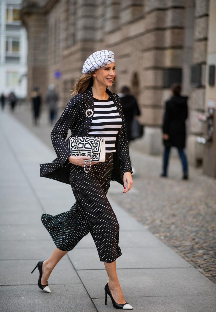 Alexandra Lapp in a tweed beret dot suit look, wearing a long black blazer with dots and matching culotte pants, black and white striped sweater with a yellow detail from Steffen Schraut, a black and white tweed beret from the Chanel La Pausa collection, a black and white 2.55 flap bag from Chanel during the Berlin Fashion Week Autumn/Winter 2019 on January 16, 2019 in Berlin, Germany. (Photo by Christian Vierig/Getty Images)