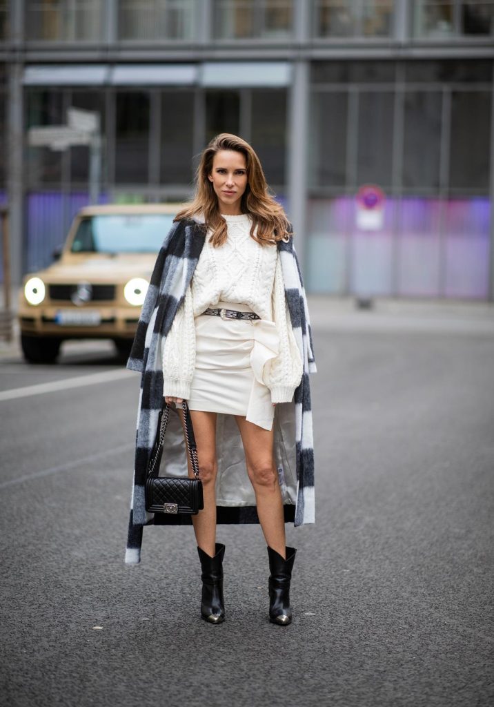 Alexandra Lapp in a Mercedes-Benz Fashion Look, in front of a Mercedes G500 wearing a black and white checked wool-blend coat from Ganni, off-white cable knit sweater from Maje, Isabel Marant ruffled skirt Nefly in off-white, embroided and silver buckled Tety belt and Lamsy ankle cowboy boots with silver tip from Isabel Marant, black Le boy bag from Chanel, Chanel brooch with Coco Chanel detail during the Berlin Fashion Week Autumn/Winter 2019 on January 16, 2019 in Berlin, Germany. (Photo by Christian Vierig/Getty Images)