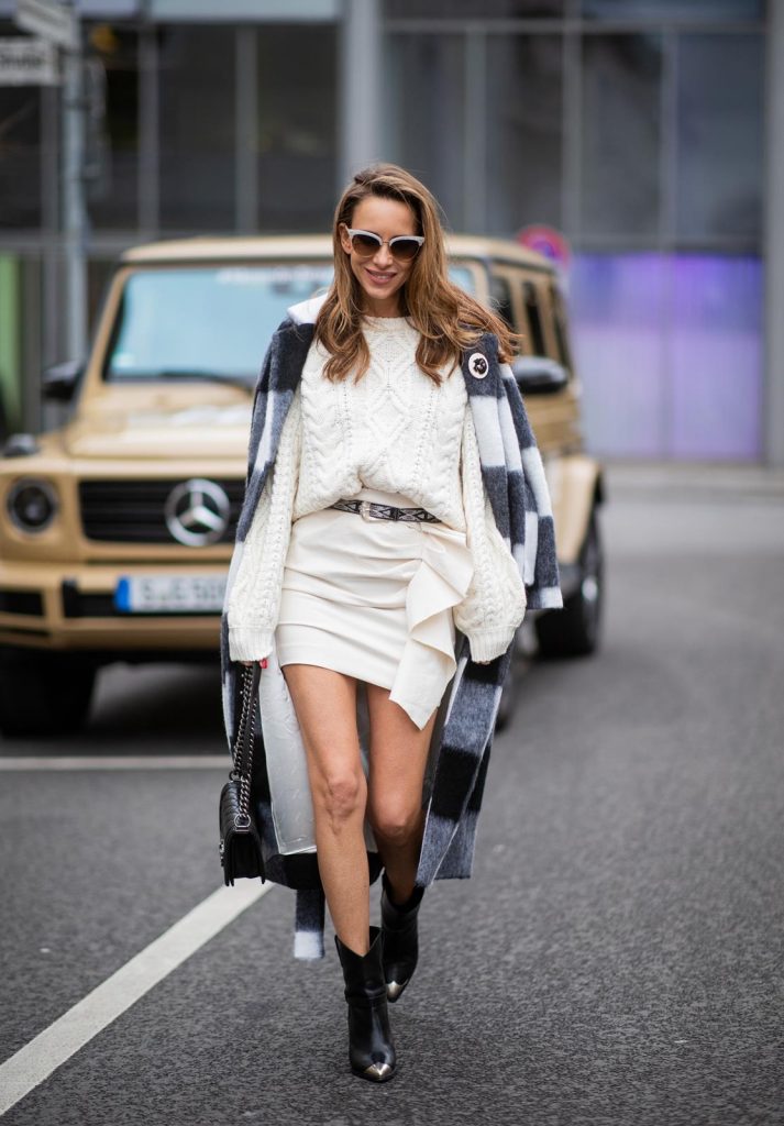 Alexandra Lapp in a Mercedes-Benz Fashion Look, in front of a Mercedes G500 wearing a black and white checked wool-blend coat from Ganni, off-white cable knit sweater from Maje, Isabel Marant ruffled skirt Nefly in off-white, embroided and silver buckled Tety belt and Lamsy ankle cowboy boots with silver tip from Isabel Marant, black Le boy bag from Chanel, Chanel brooch with Coco Chanel detail during the Berlin Fashion Week Autumn/Winter 2019 on January 16, 2019 in Berlin, Germany. (Photo by Christian Vierig/Getty Images)