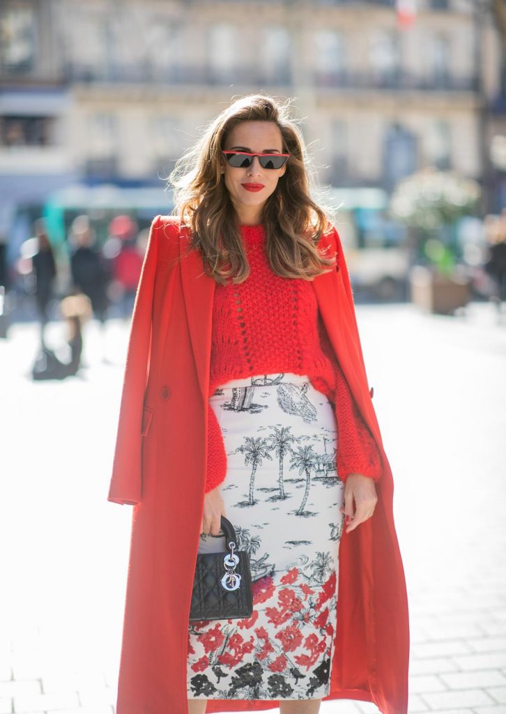 Alexandra Lapp in a Printed Skirt look, wearing a fitted two button coat in bright red from Givenchy, with a NO.21 sequined twill pencil skirt with a Palm-print, a red wool loose knit sweater from Ganni - all from Breuninger, black sandals from Gianvito Rossi, Prada cat-eye shaped sunglasses with red details and the Lady Dior mini bag during Paris Fashion Week Womenswear Fall/Winter 2019/2020 on February 26, 2019 in Paris, France. (Photo by Christian Vierig/Getty Images)