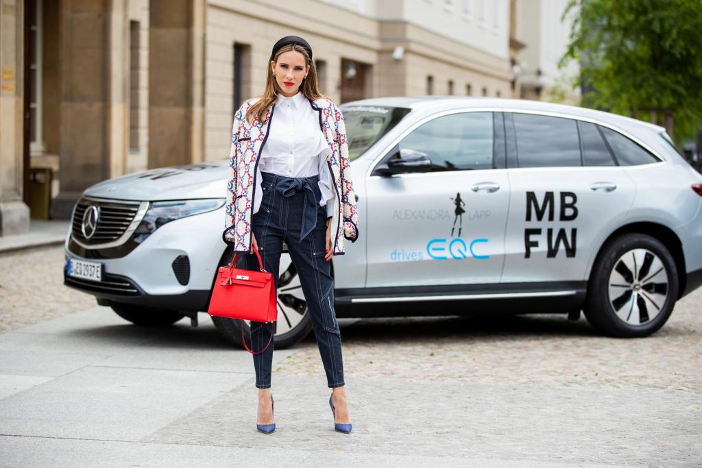 Alexandra Lapp in a Women and Technology look, is seen wearing a IWC Portofino Chronograph in front of a Mercedes EQC during MBFW Berlin.