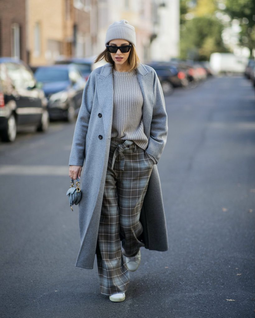 Alexandra Lapp is seen wearing a grey Max Mara cashmere coat, Christian Dior Saddle Micro bag, Iris von Arnim cashmere jumper, cashmere beanie, high waist pants, Celine sunglasses and Veja sneakers.