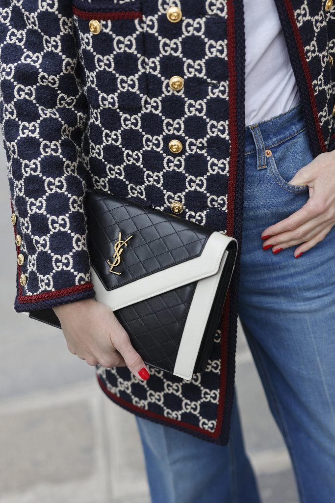 Alexandra Lapp is seen wearing the GUCCI logo print Caban Jacket in the Gucci pattern, JAMES PEARSE t-shirt in white, GUCCI washed denim flair trousers with Gucci label, GIANVITO ROSSI ribbon point flats in vitello white, SAINT LAURENT handbag in black and white, and BOTTEGA VENETA square acetate sunglasses in black. Complete look by Breuninger.