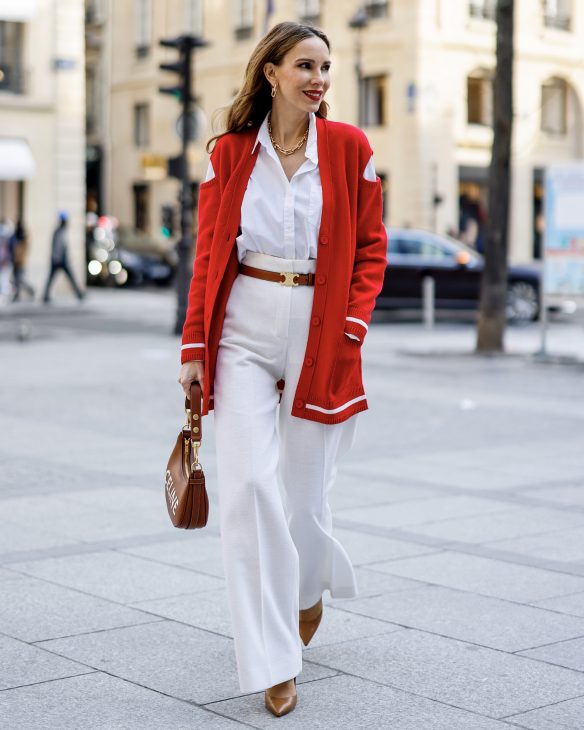 Alexandra Lapp is seen wearing colorful looks during Paris Fashion week by GIVENCHY cut-out shoulder cardigan in red, JIL SANDER blouse in white, MAX MARA wide legged pants in creme, CELINE belt in cognac, CELINE Ava strap bag in cognac, CELINE sunglasses, and CHRISTIAN LOUBOUTIN So Kate pumps in cognac. Total look via La Boutique Conceptstore, Dresden.