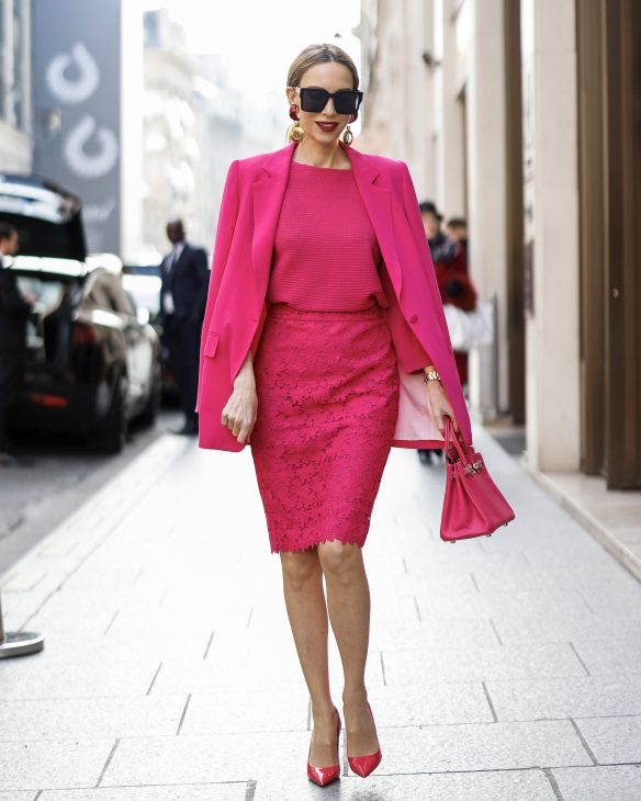 Alexandra Lapp is seen wearing colorful looks during Paris Fashion Week, MADELEINE blazer in pink, MADELEINE knit jumper in pink, MADELEINE lace skirt in pink, and PRADA pumps in pink and HERMES mini birkin bag.
